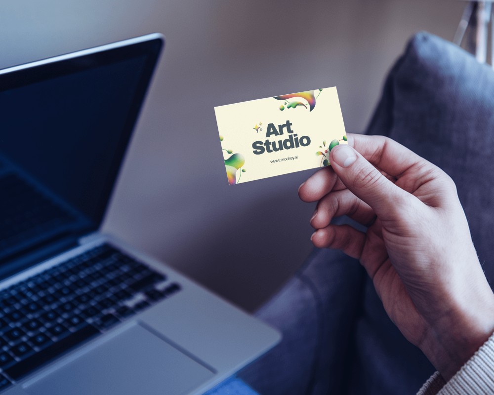 Hand Holding Business Card Over Laptop For Professional Corporate Environment Mockup