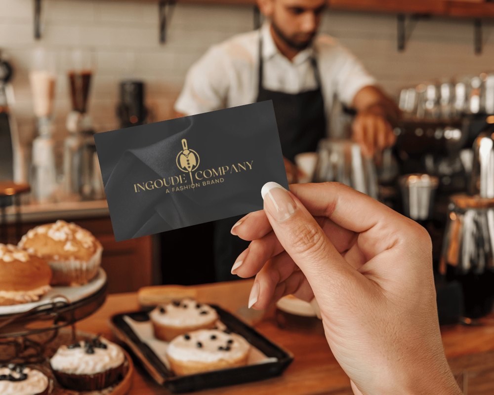 Cozy Cafe Business Card Mockup Hand Holding Card Near Pastries And Barista In Warm Lighting