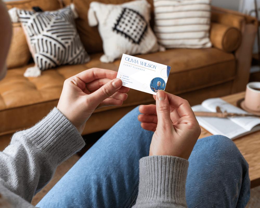 Cozy Living Room Business Card Mockup Hand Holding Card Over Stylish Interior Background