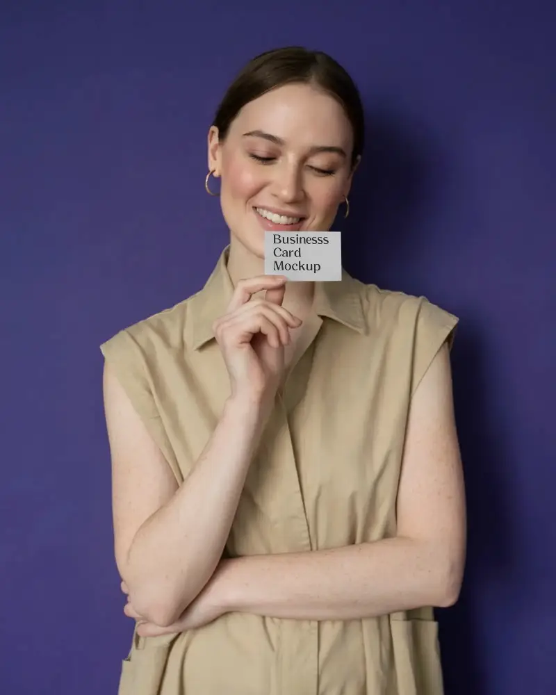 Smiling Woman Holding Minimalist Business Card Mockup Against Solid Color Background