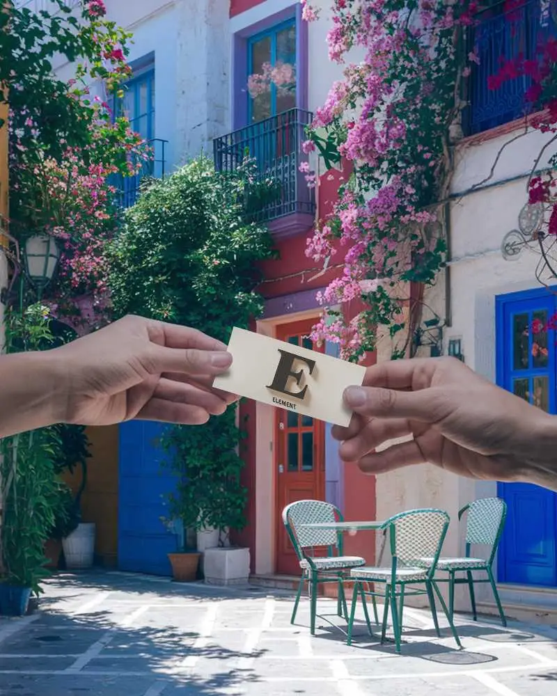 Colorful European Backdrop Business Card Mockup Holding Card Between Two Hands In Cozy Courtyard 0171