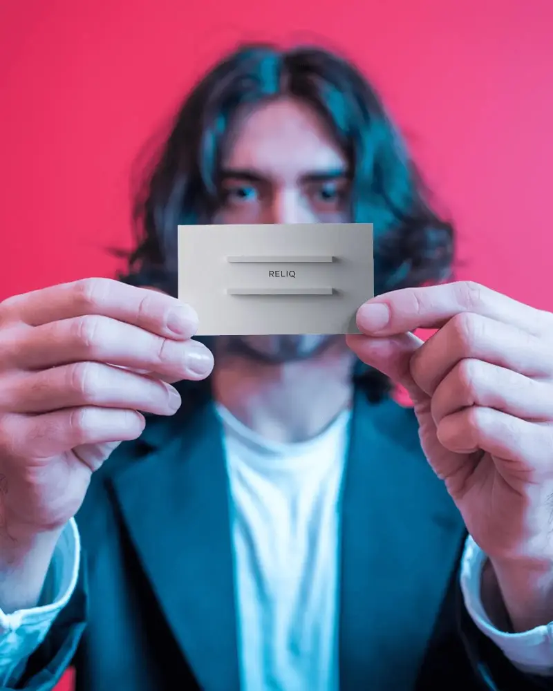 Bold Red Background Business Card Mockup Man Holding Card Toward Camera With Focus On Hands 0172