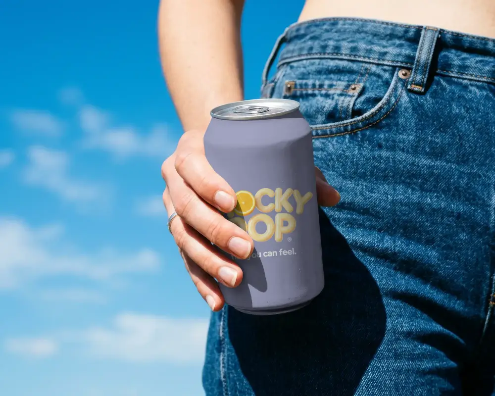 Person Holding Standard Can Mockup Against Clear Blue Sky Background For Beverage Branding