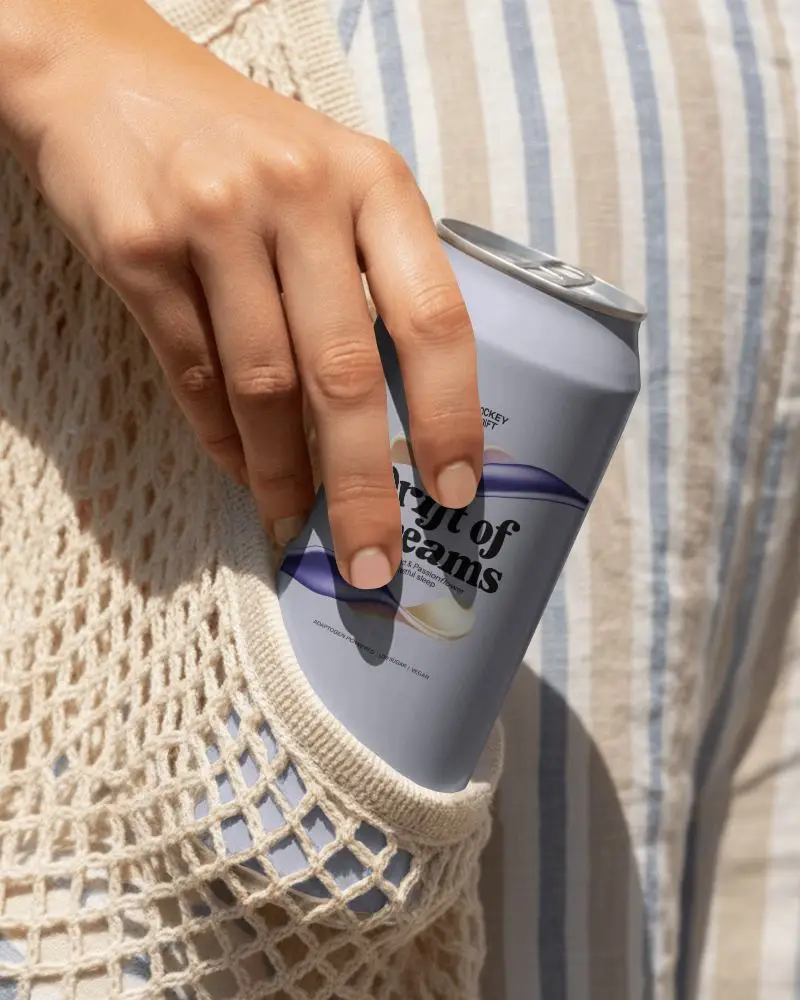Hand Holding Soda Can Mockup With Mesh Tote Bag And Sunlit Summer Lifestyle Background