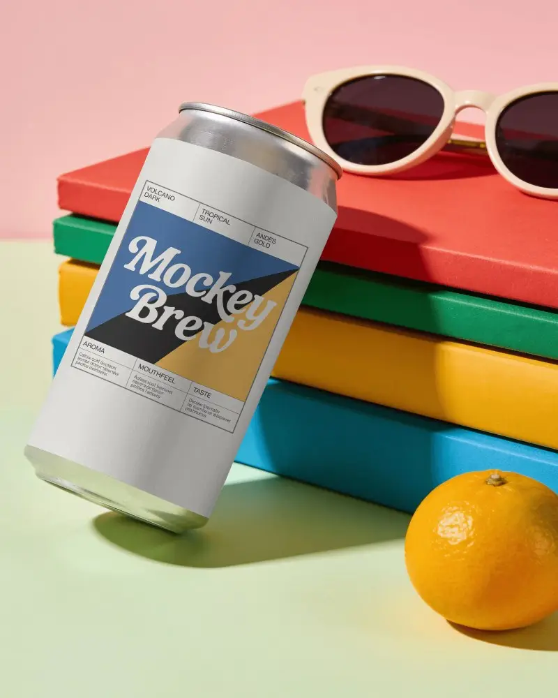 Tilted Beer Can Mockup With Colorful Stacked Books Sunglasses And Orange Fruit In Bright Studio
