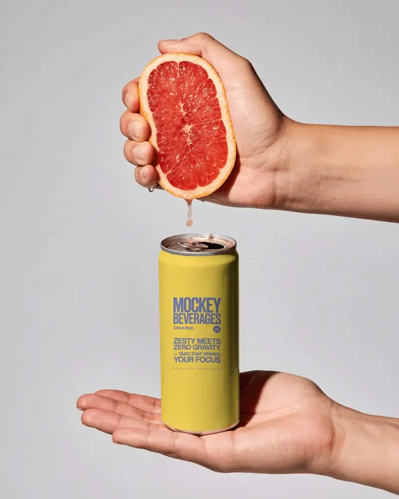 Fresh Grapefruit Soda Can Mockup With Hand Squeezing Citrus Juice Above Clean Product Display