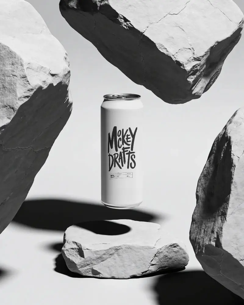 Sleek Minimalist Beverage Can Mockup Surrounded By Rough Stone Textures For Design Needed