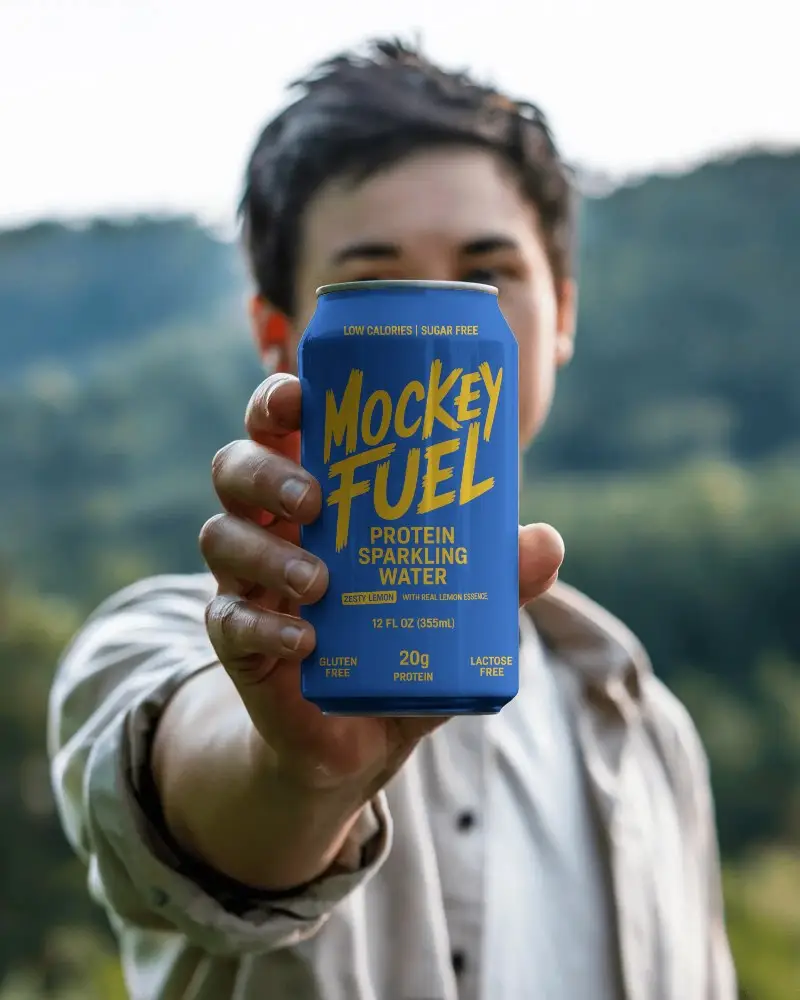 Outdoor Can Mockup Held By Man In Natural Scenic Background Close Up Focus On Metal Surface