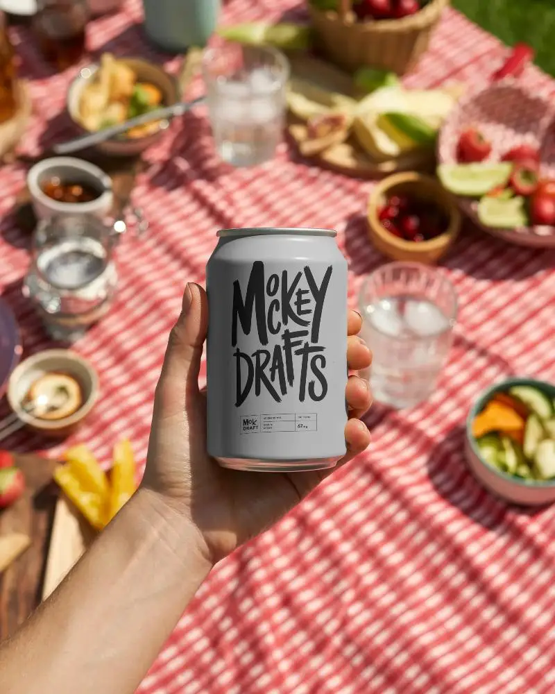 Beverage Can Mockup Showcased In Natural Light Picnic Setting With Food Background