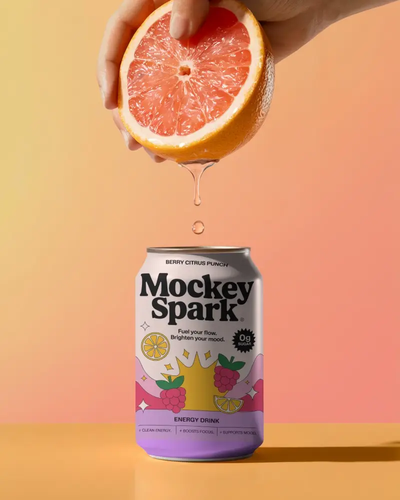 Citrus Drip Can Mockup Hand Holding Fruit Above Can Gradient Background Bright Refreshing Scene