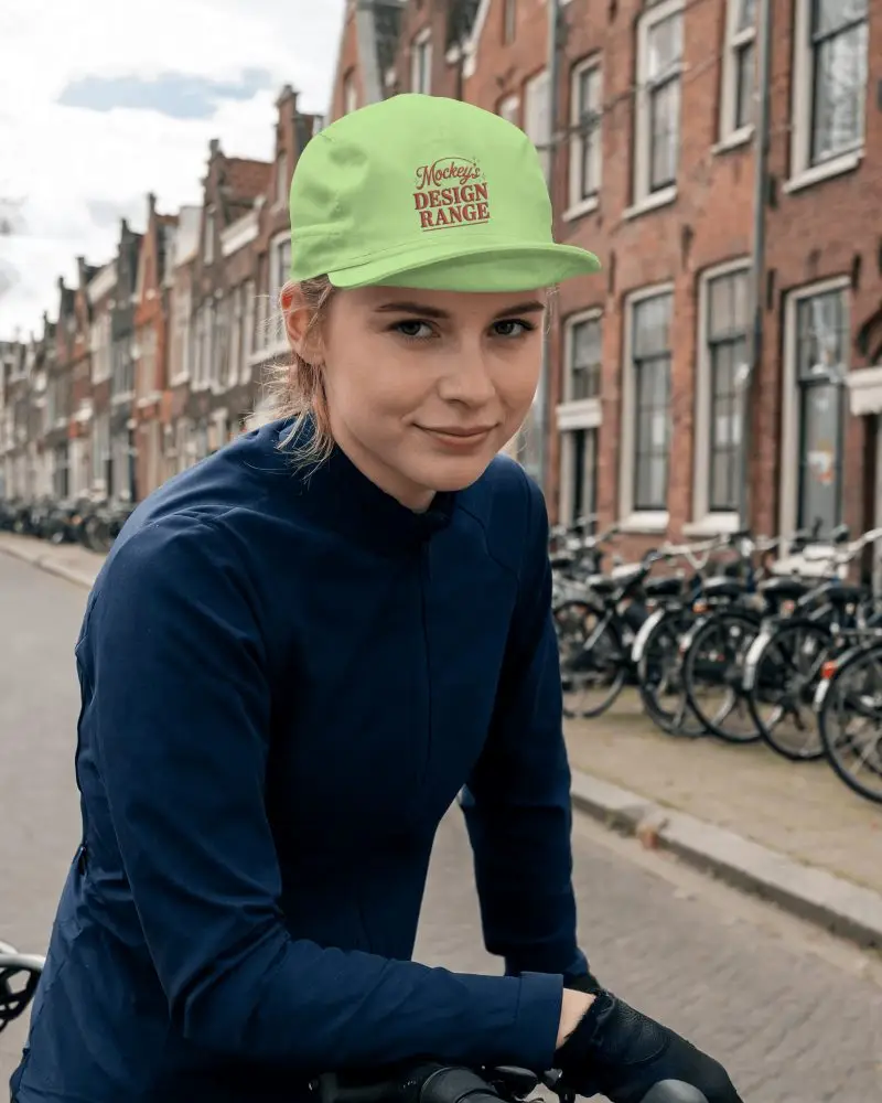 Female Cyclist Wearing Cycling Cap Leaning Forward On Bike In Urban Street Environment