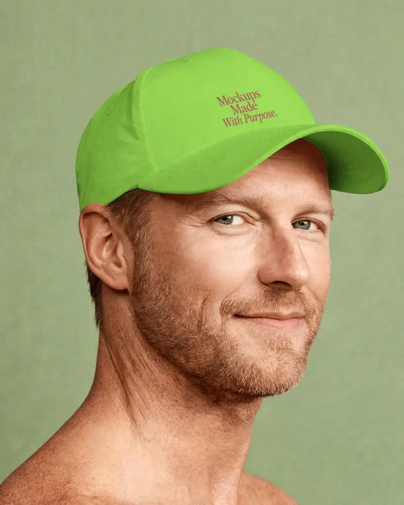 Male Model Wearing Baseball Cap Looking Over Shoulder With Subtle Smile And Soft Studio Light