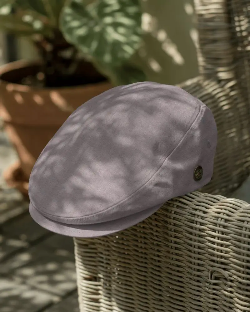 Sun Dappled Flat Cap Mockup Placed On Wicker Chair In Garden Setting With Leaf Shadows Falling