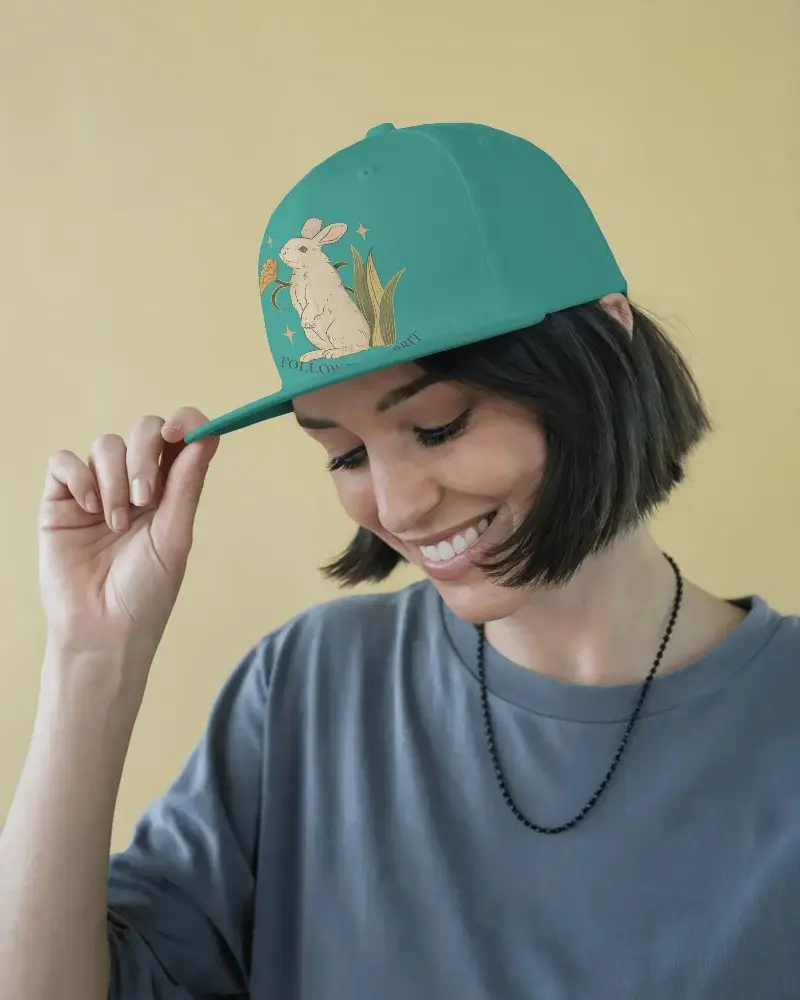 Stylish Snapback Hat Customization Mockup Female Model Holding Cap And Showing Your Design In Light Gray Shirt