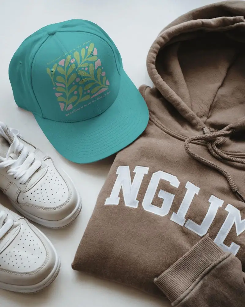 Top Down Streetwear Cap Mockup Beside Brown Hoodie And Trendy Sneakers For Brand Showcase