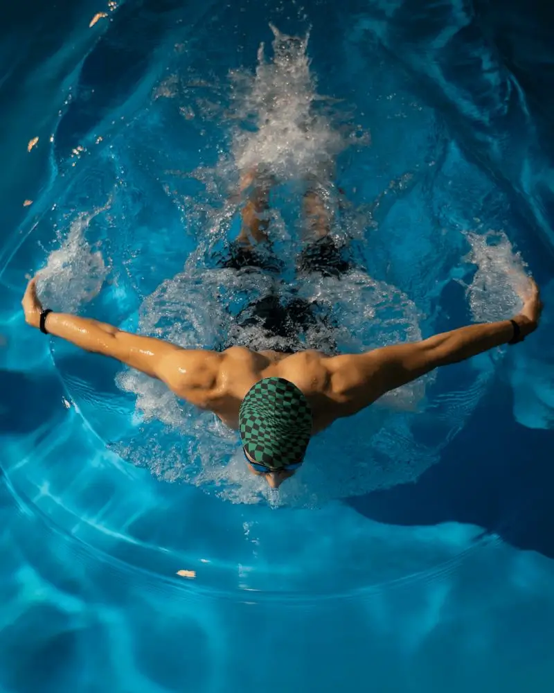 Underwater Swim Cap Mockup Male Swimmer In Motion Top View In Vibrant Deep Pool With Splashing Water