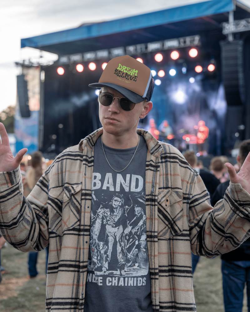 Music Festival Trucker Hat Mockup Trendy Male Model In Plaid Shirt And Band Tee With Stage Lights