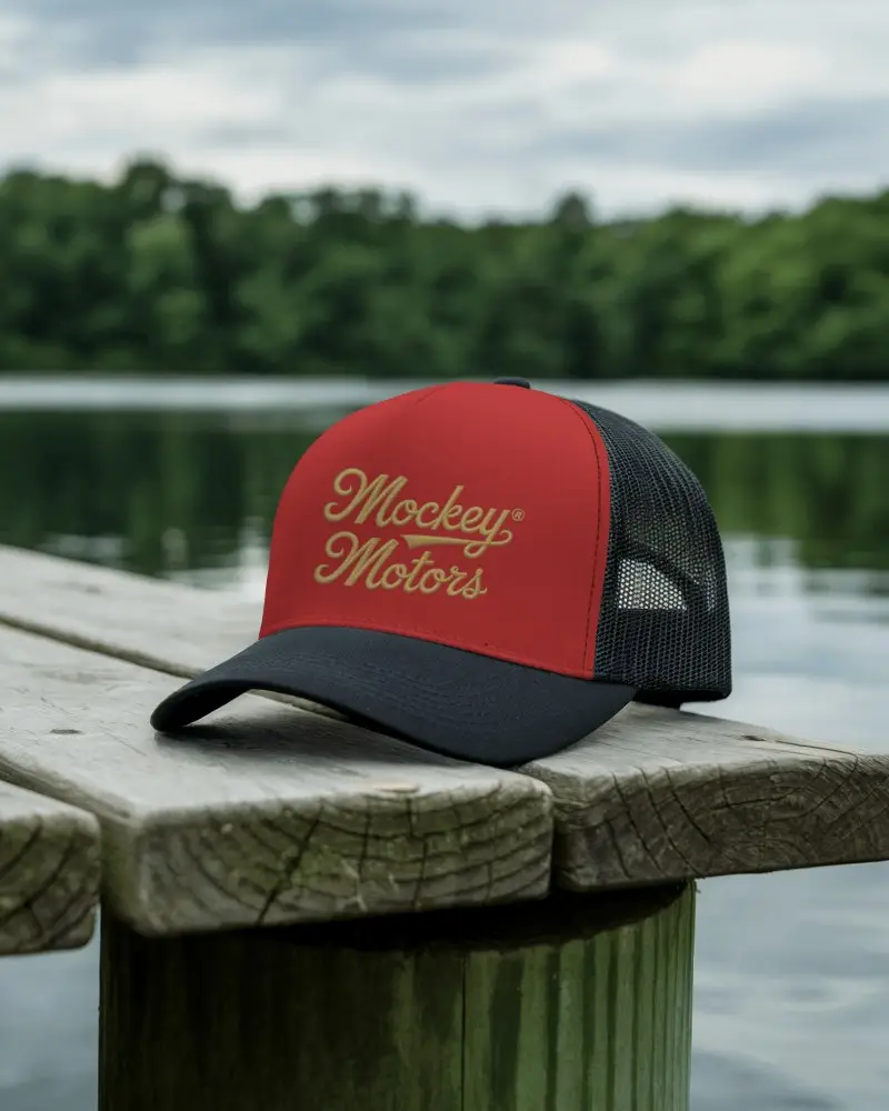 Lakeside Trucker Hat Mockup Dark Cap On Dock Over Calm Water With Forest In Soft Natural Light