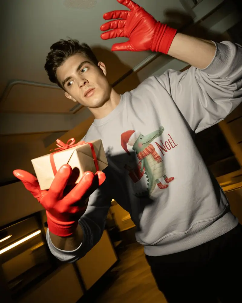 Modern Christmas Sweatshirt Mockup Male Model With Red Gloves Holding Gift In Studio Light