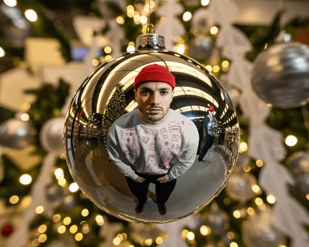 Creative Christmas Sweatshirt Mockup Man Reflected In Bauble With Tree Lights