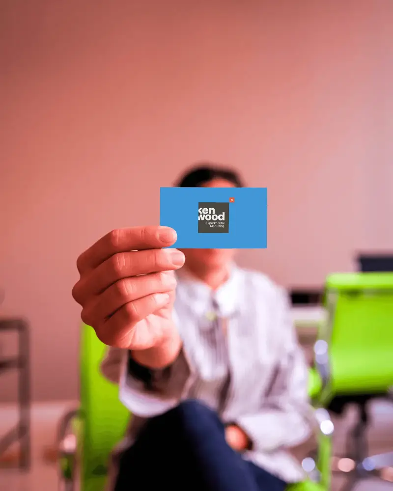 Person Holding Blank Business Card Logo Mockup In Office For Branding And Marketing Purposes
