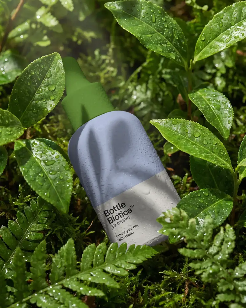 Eco Friendly Cosmetic Bottle Mockup Surrounded By Fresh Wet Leaves For Organic Products