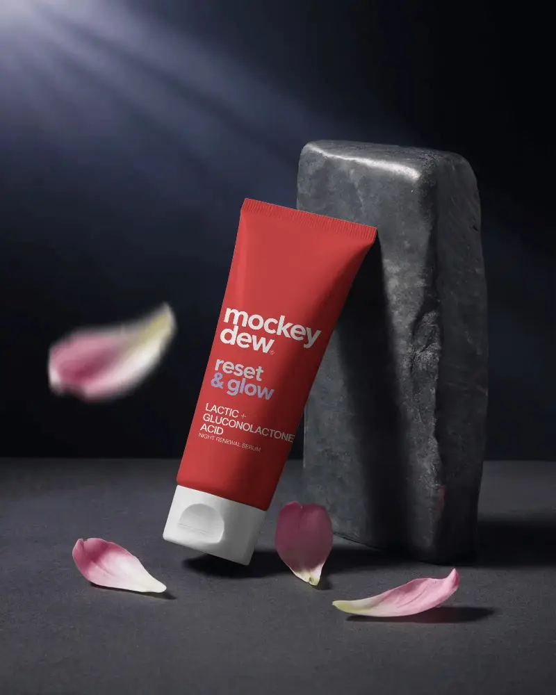 Elegant Skincare Tube Mockup Set Against Dark Stone With Delicate Petal Decoration