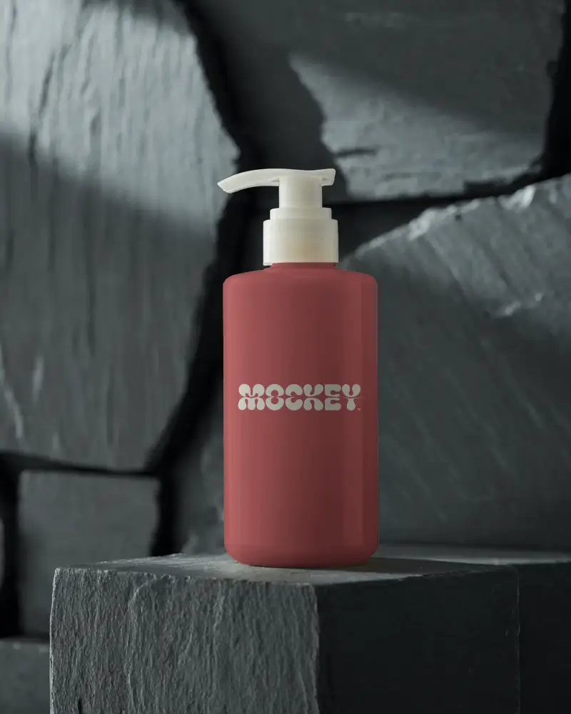 Sleek Cylindrical Pump Cosmetic Bottle Standing On Textured Stone Block For Skin Care