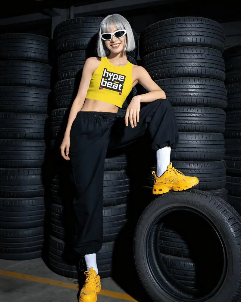 Garage Sleeveless Crop Top Mockup Female Model Smiling With Sunglasses And Tire Stack Background