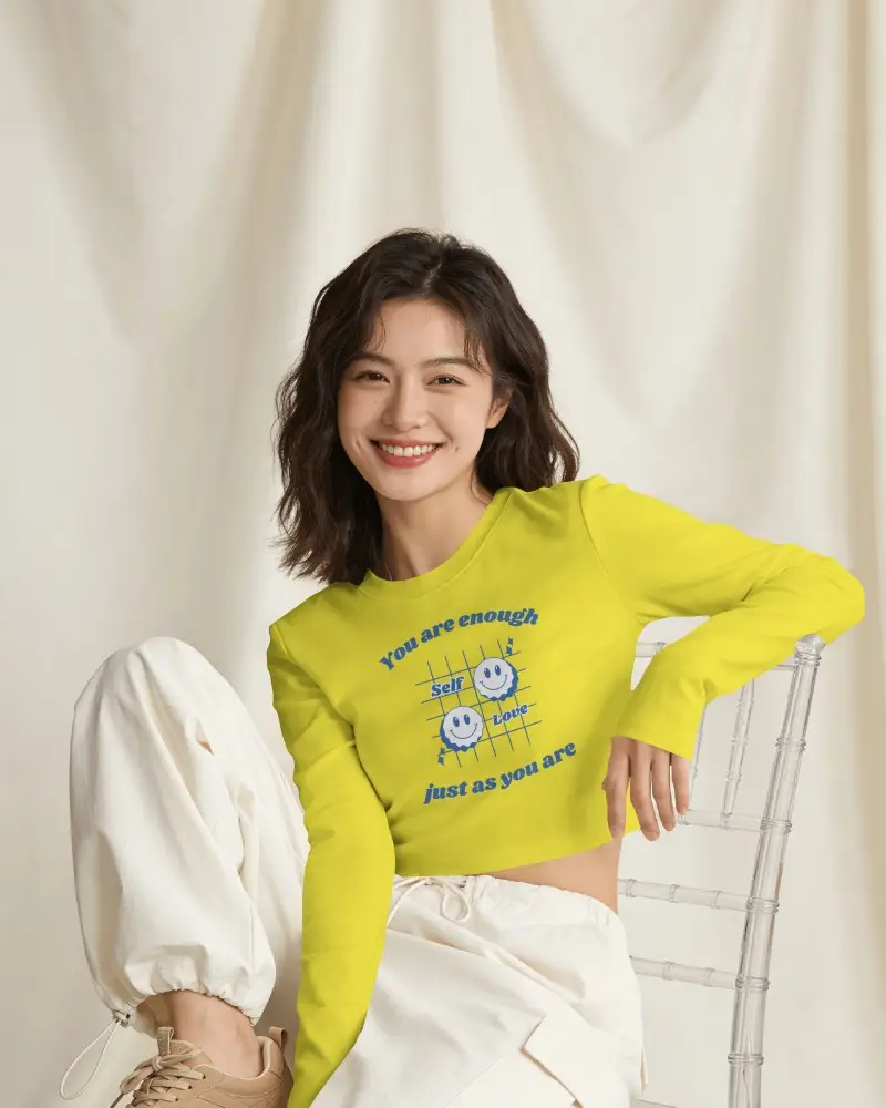 Long Sleeve Crop Top Mockup Female Model Sitting On Clear Chair With Soft Draped Fabric Background