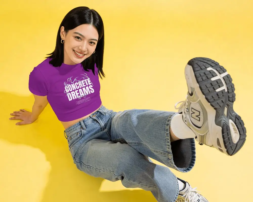 Short Sleeve Crop Top Mockup Female Model Sitting On Bright Yellow Floor With Playful Kick Pose