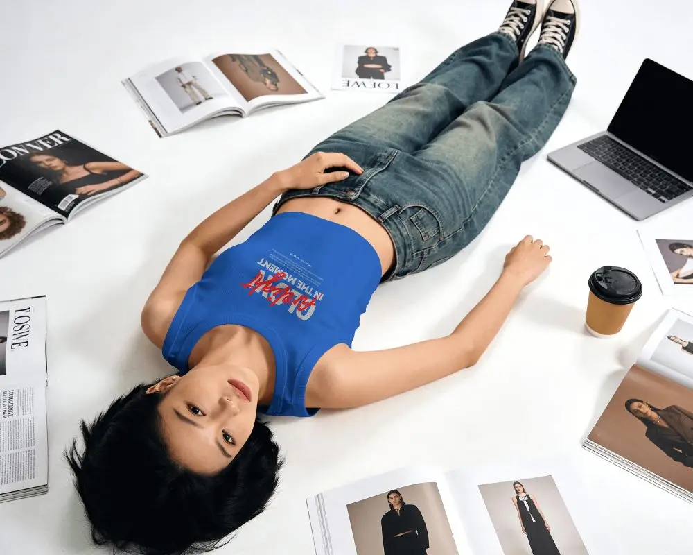 Stylish Crop Top Mockup Model Posing On Floor Surrounded By Fashion Magazines And Laptop