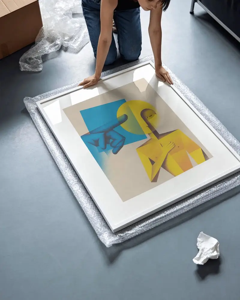 Person Kneeling On Floor Unpacking Large Frame Mockup For Wall Art Display