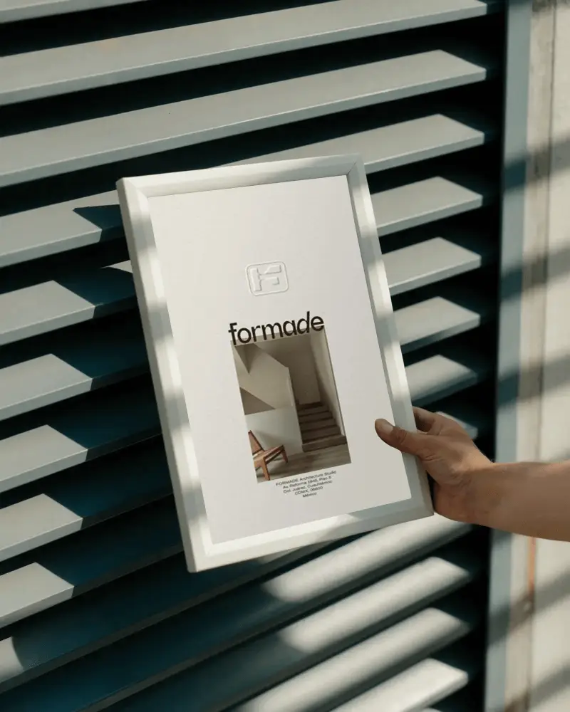 Hand Holding Blank Photo Frame Against Modern Architectural Background For Design