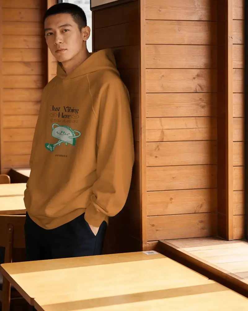 Front Facing Hoodie Mockup Leaning On Wooden Wall Warm Light Cozy Style Look
