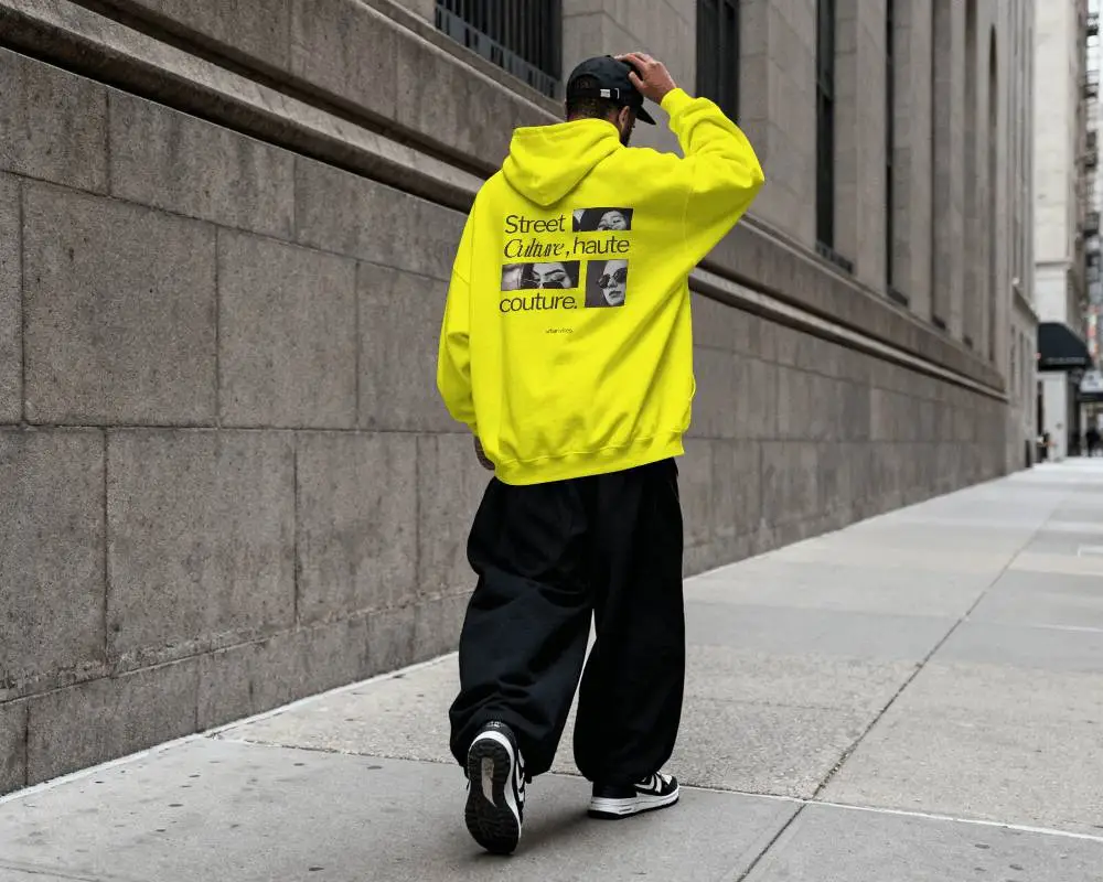 Urban Hoodie Mockup Back View Male Model Walking Along Concrete Sidewalk In Minimal City Setting