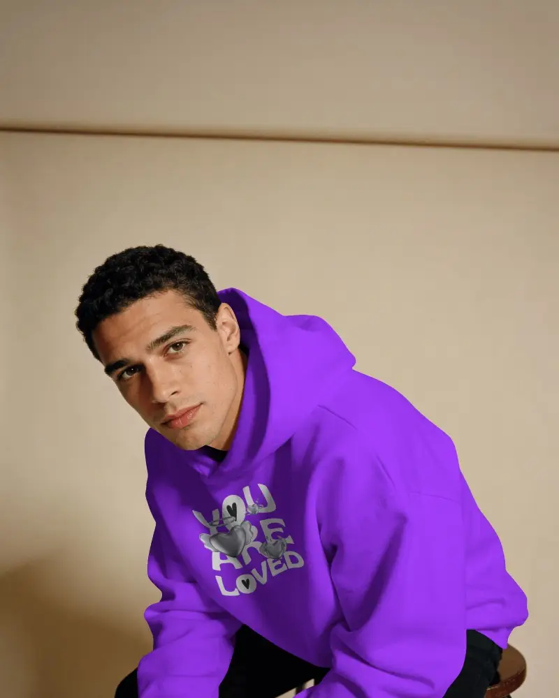 Printful Hoodie Mockup Front View Male Model Leaning Forward In Warm Minimal Indoor Studio