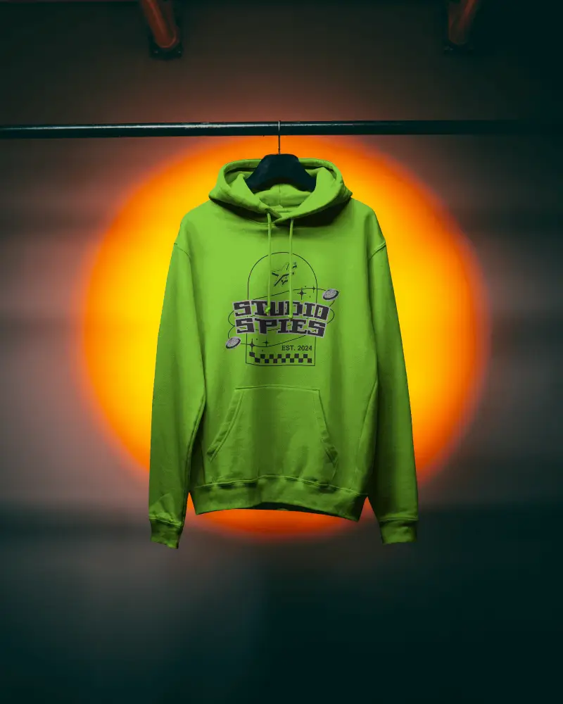 Front View Hoodie Mockup Hanging Display Against Warm Orange Light Centerpiece In Dark Room 0763