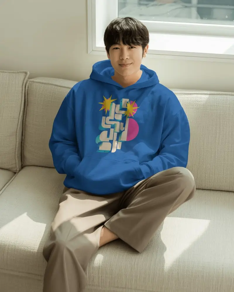 Sunlit Window Sofa Hoodie Mockup Male Model Relaxing In Bright Living Room
