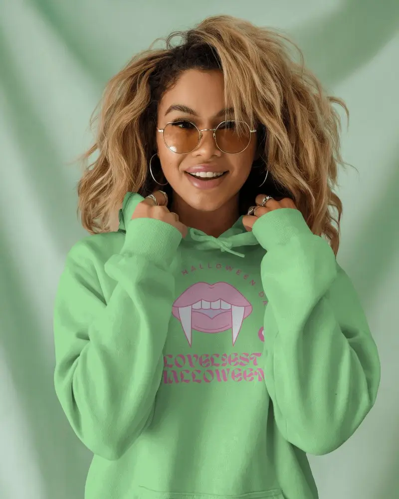 Cheerful Female Hoodie Mockup With Smiling Model In Sunglasses Pulling Hoodie Against Pastel Green Background