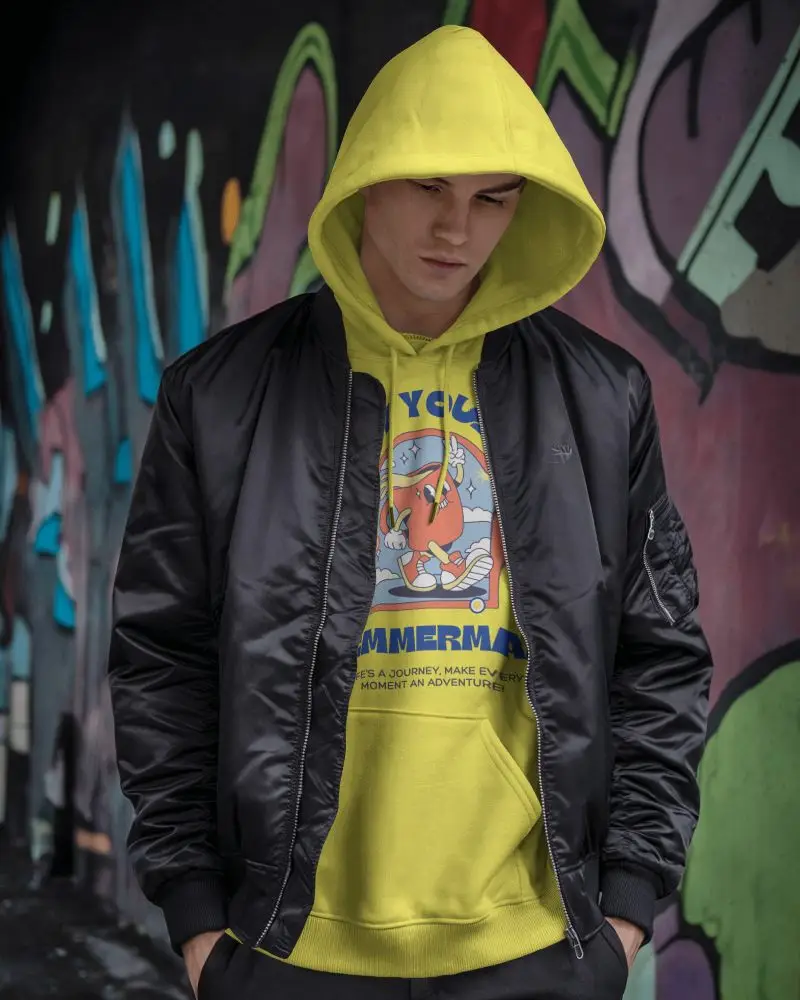 Urban Streetwear Hoodie Mockup With Male Model In Bomber Jacket And White Hoodie Against Graffiti Wall