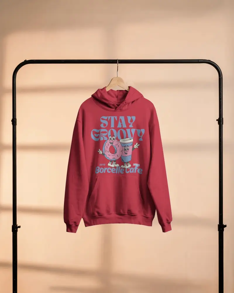 Pastel Lit Hoodie Mockup Hanging On Wooden Hanger Against Warm Studio Background