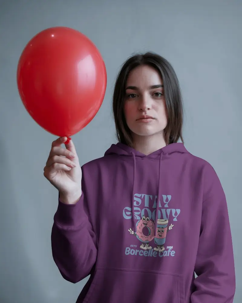 Bold Expression Hoodie Mockup Female Model Holding Red Balloon Against Muted Grey Backdrop In Contrast Light 0592