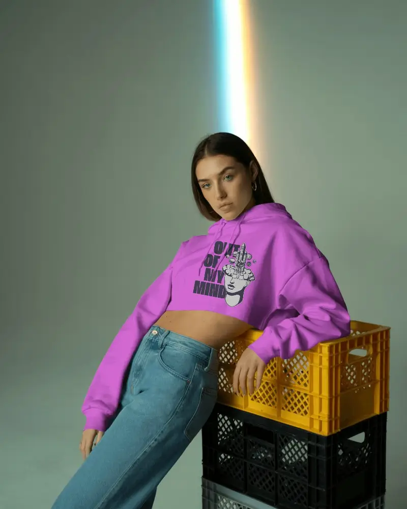 Edgy Studio Cropped Hoodie Mockup Female Model Leaning On Yellow Crate With Rainbow Light Effect 0593
