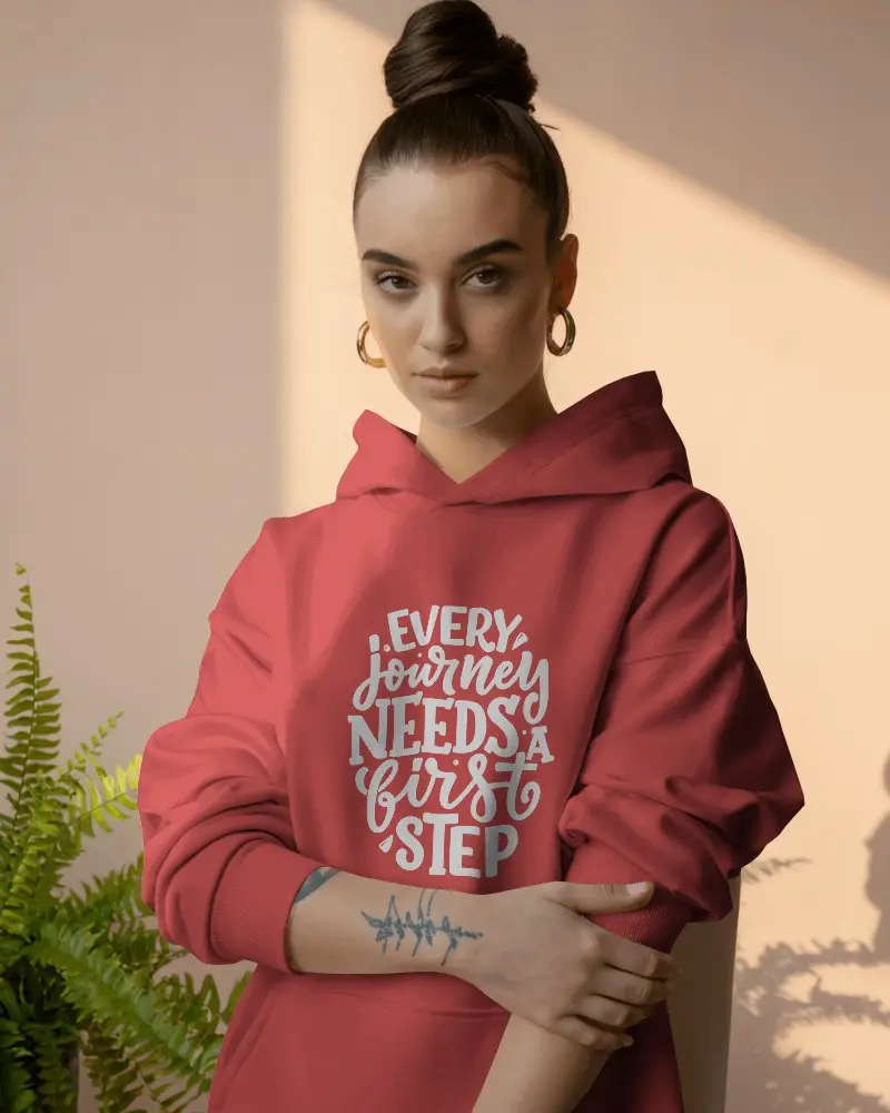 Sunlit Interior Hoodie Mockup Female Model With Top Bun And Arm Tattoo Standing By Plant In Warm Studio Light 0598