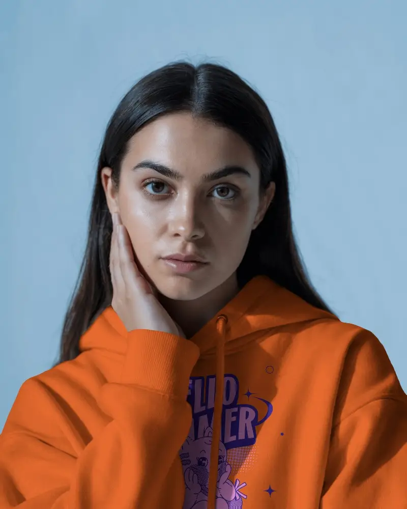 Close Up Hoodie Mockup With Serene Female Model Touching Face Against Light Blue Background For Softwear Brand Promo