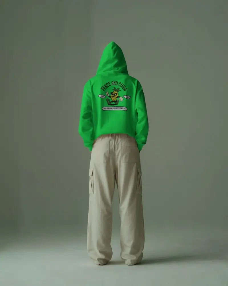 Minimalist Studio Hoodie Mockup Back View Male Model Wearing Beige Cargo Pants Against Muted Green Backdrop