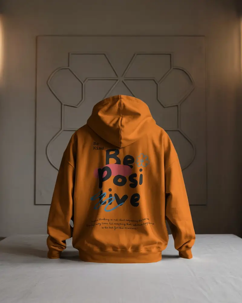 Minimalist Indoor Hoodie Mockup Back View Model Kneeling On White Table Against Geometric Wall Art