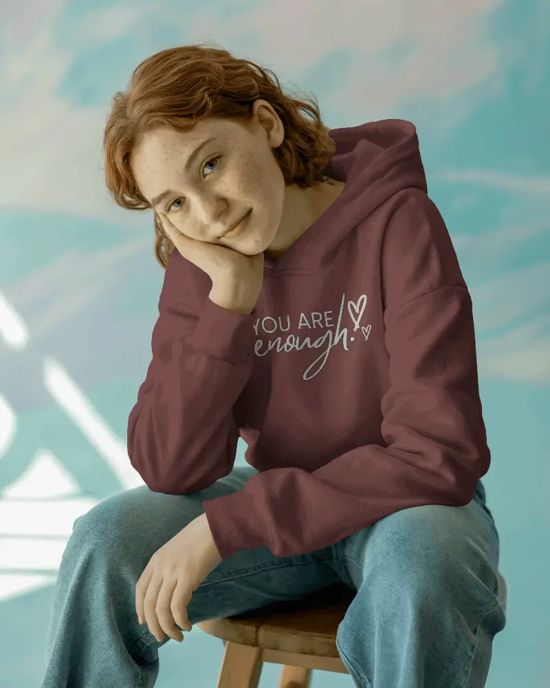Cozy Hoodie Mockup Seated Model On Soft Colorful Blurred Backdrop