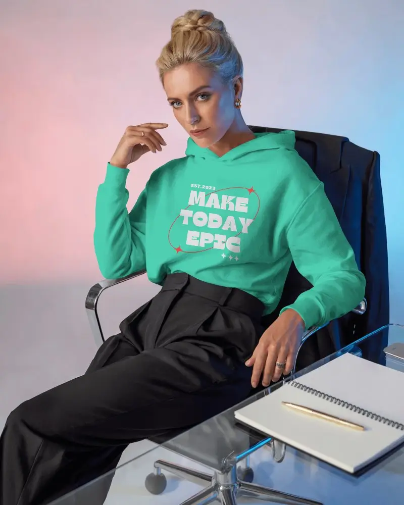 Executive Style Hoodie Mockup Female Model In Modern Office Chair With Notebook On Glass Table 0797